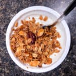 toasted granola with pecans and almonds on a cup of yogurt