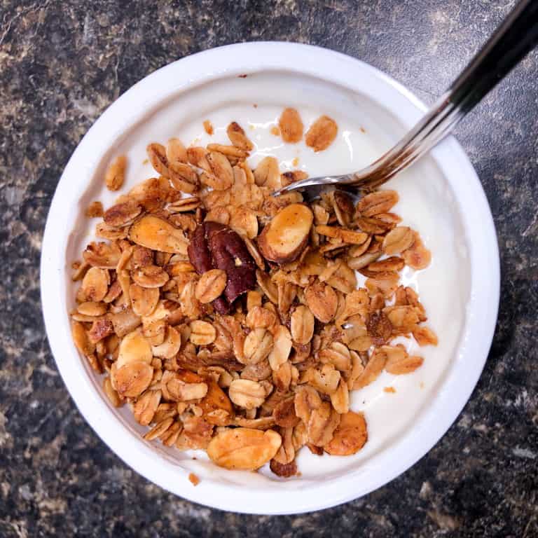 toasted granola with pecans and almonds on a cup of yogurt