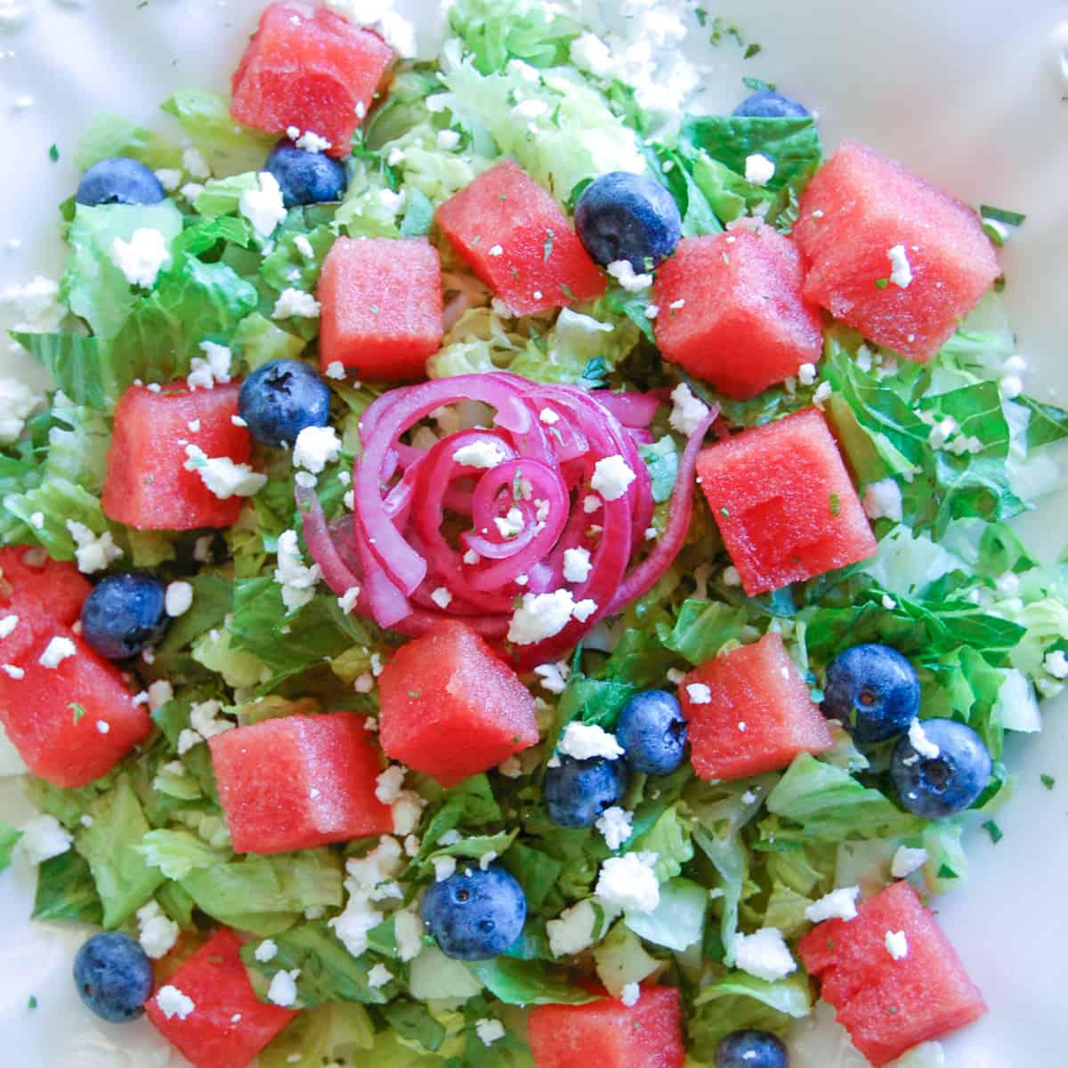summer watermelon salad: chopped romaine, blueberries, diced watermelon, pickled red onions, and crumbled feta