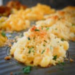 close up view of mac and cheese cup with bread crumb topping in muffin pan