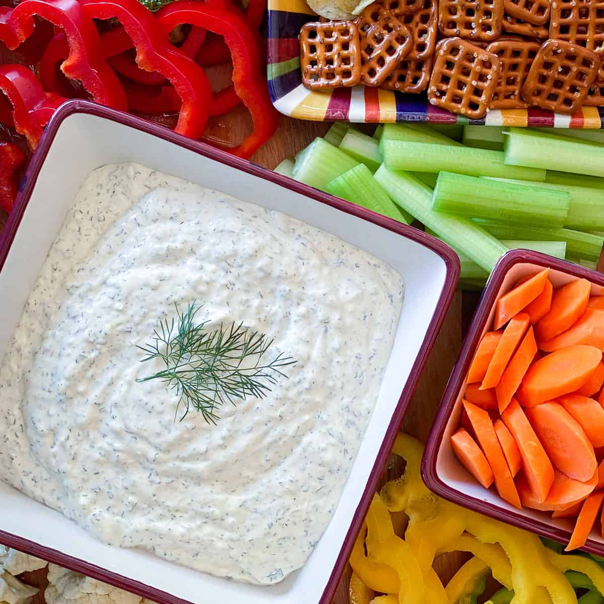 vegetable dip on tray with assorted vegetables and pretzels
