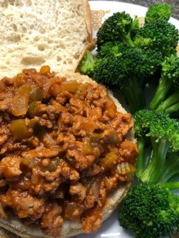 open faced bun with turkey sloppy joe and steamed broccoli on plate