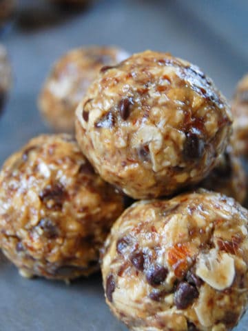 close up of energy balls made of peanut butter, oats, and mini chocolate chips on sheet pan